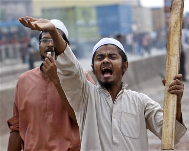 An Islamic activist armed with a stick shouts as he enforces a 30-hour nationwide strike at Kachpur, outskirts of Dhaka, Bangladesh, on Sunday. Riot police in Bangladesh fired tear gas shells to disperse thousands of Islamist activists trying to enforce an anti-government general strike which has been called by a coalition of 12 Islamic parties to protest removal of a clause from the country's constitution that expressed "absolute faith and trust in Allah."